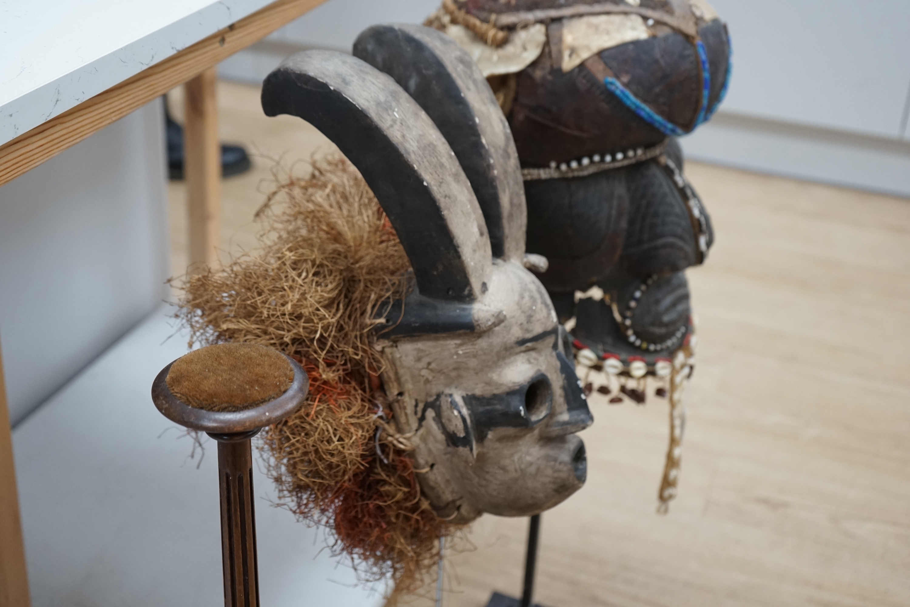 An African Kuba helmet mask and another horned mask, both on stands & one spare. Condition - helmet mask damaged